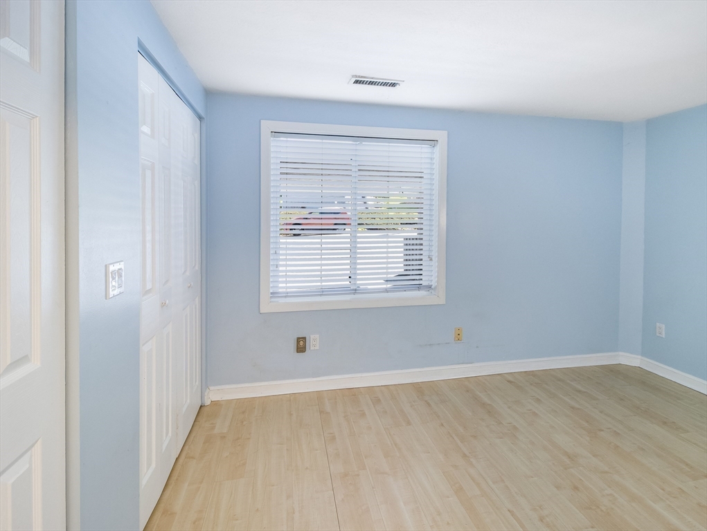 16 Milford Street, Unit 9 Hull, MA 02045 - Photo 19 of 42 a view of an empty room with wooden floor and a window