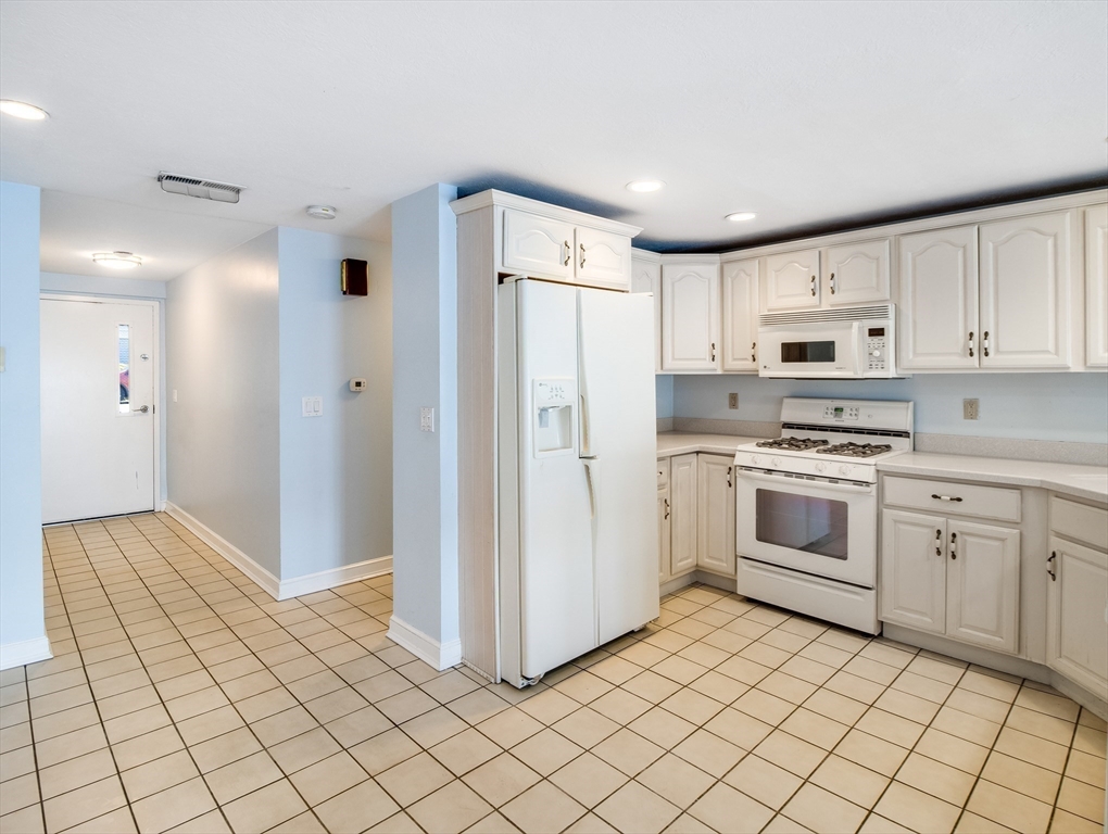 16 Milford Street, Unit 9 Hull, MA 02045 - Photo 8 of 42 a kitchen with white cabinets and white appliances