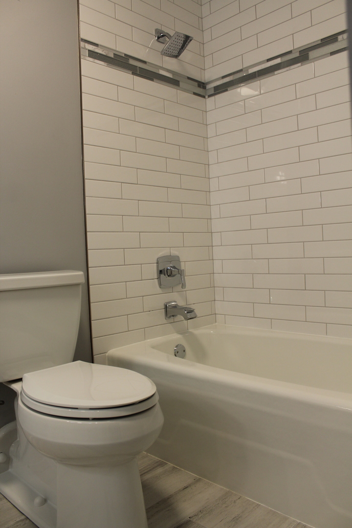 1605 East Central Road, Unit 413B Arlington Heights, IL 60005 - Photo 13 of 15 a white toilet sitting next to a bath tub and a shower