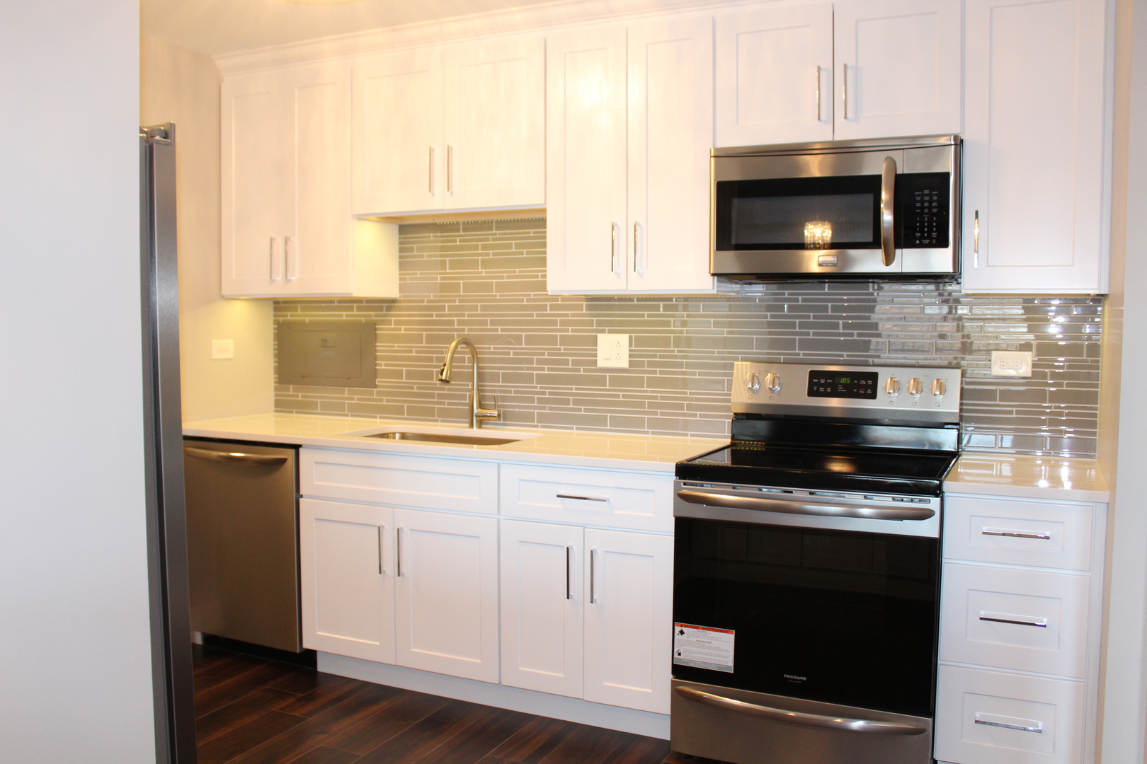 1605 East Central Road, Unit 413B Arlington Heights, IL 60005 - Photo 3 of 15 a kitchen with a stove and a microwave