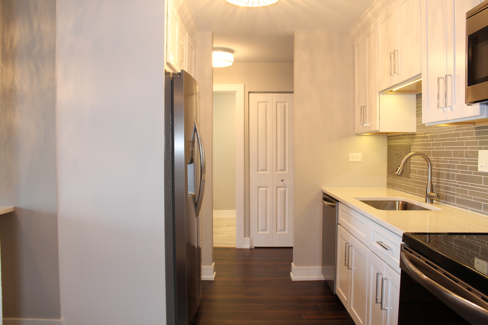 1605 East Central Road, Unit 413B Arlington Heights, IL 60005 - Photo 4 of 15 a kitchen with a sink and a refrigerator