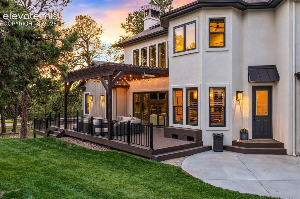 18572 Wetherill Road Monument, CO 80132 - Photo 49 of 50 Expansive backyard featuring a multi-level composite deck, dark wood pergola, and a grassy lawn