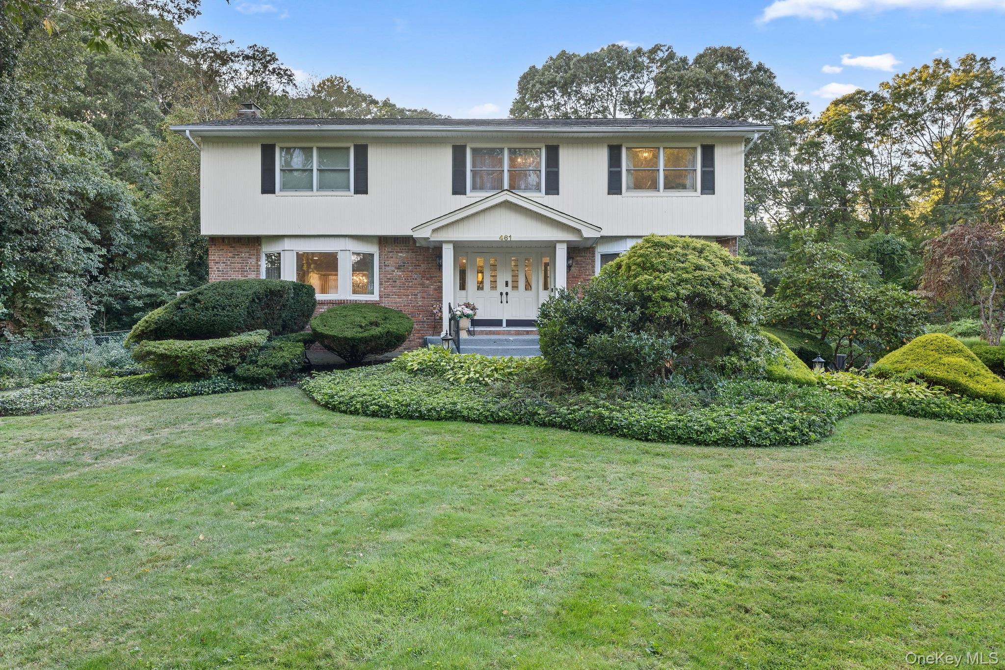 a front view of a house with a garden