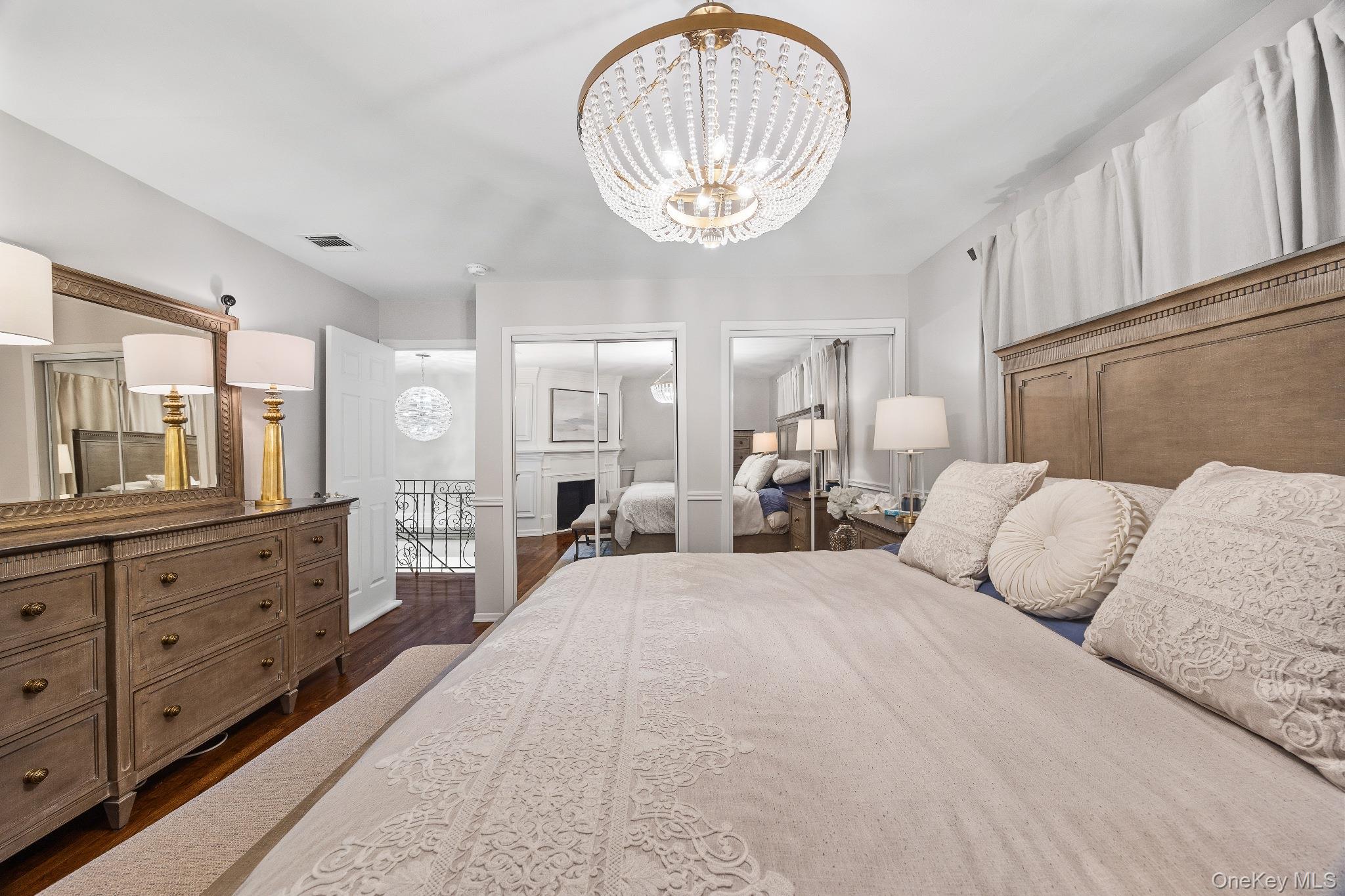 461 Wolf Hill Road Dix Hills, NY 11746 - Photo 18 of 37 a bedroom with a large bed and a chandelier