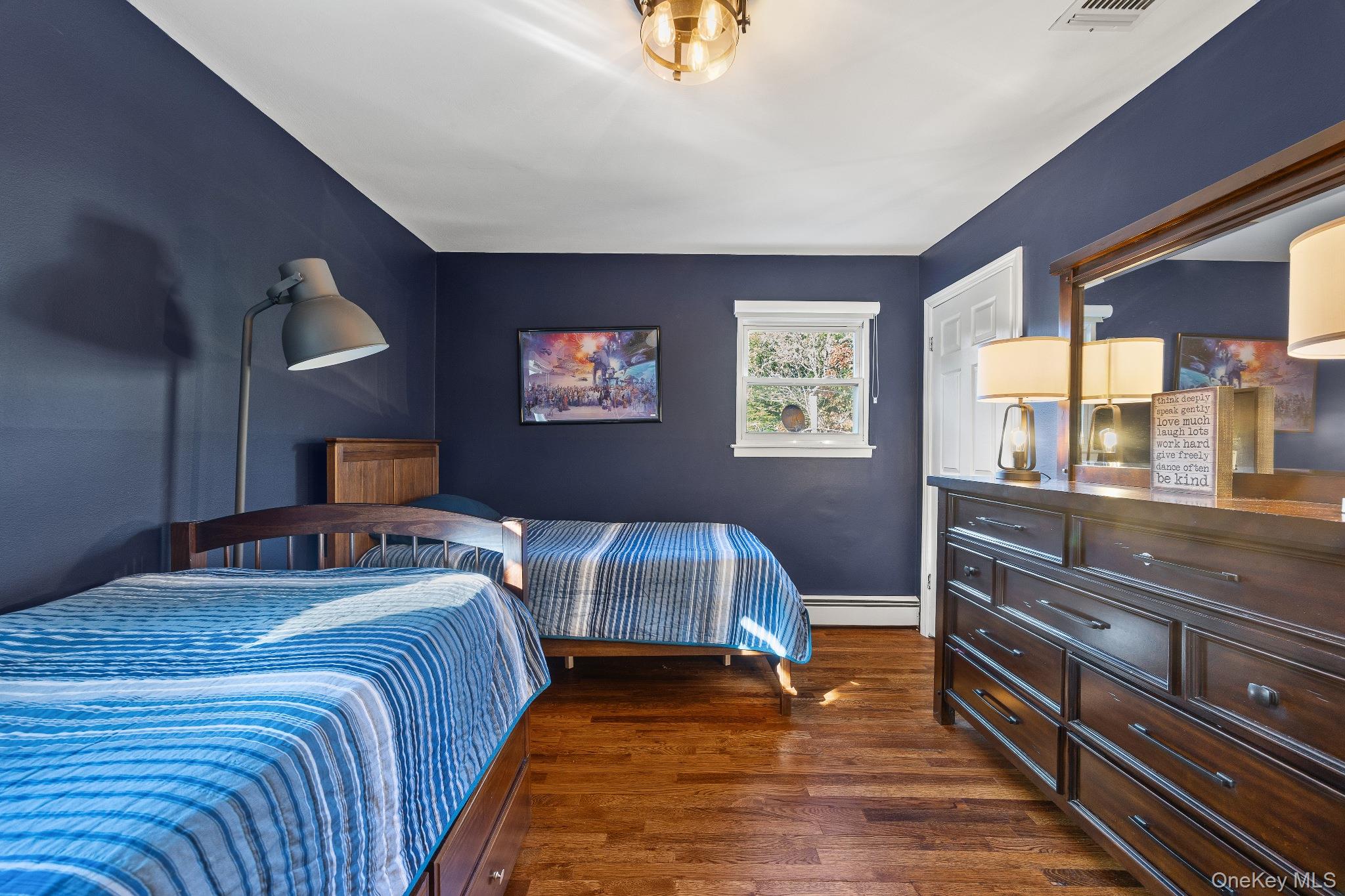 461 Wolf Hill Road Dix Hills, NY 11746 - Photo 22 of 37 a bedroom with a bed and a lamp on dresser with wooden floor