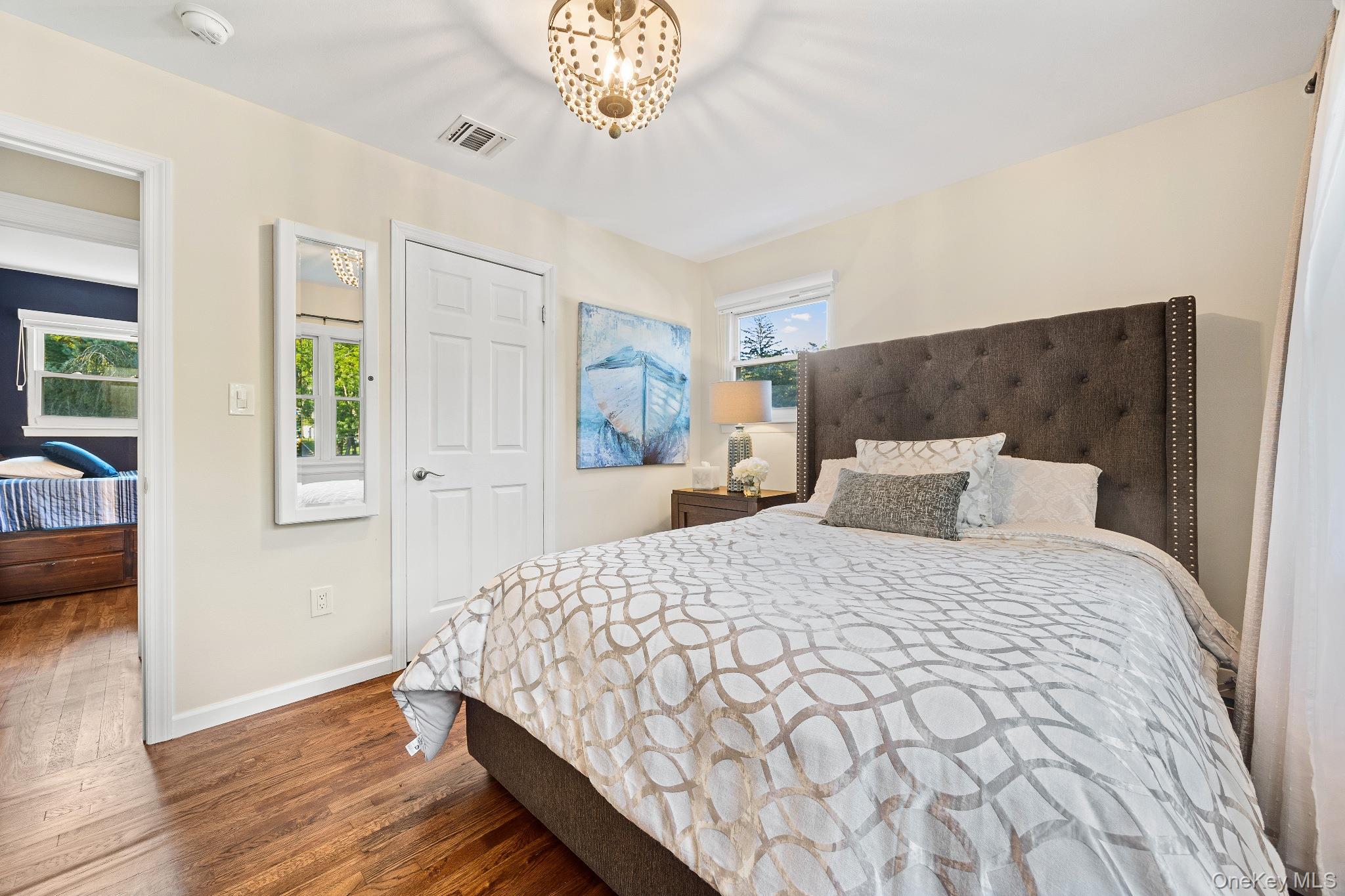 461 Wolf Hill Road Dix Hills, NY 11746 - Photo 26 of 37 a bedroom with a large bed and a chandelier