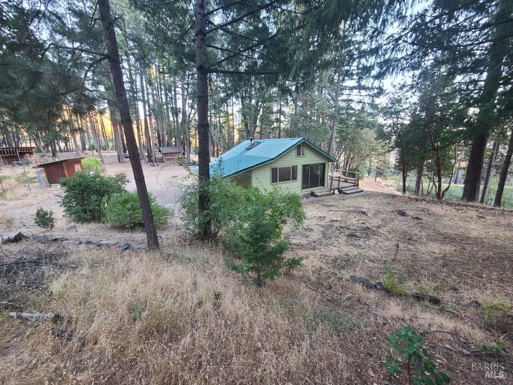 41390 Mendocino Pass Road Covelo, CA 95428 - Photo 40 of 44 a front view of a house with a garden and trees