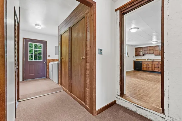 a view of a hallway with a livingroom and a bathroom