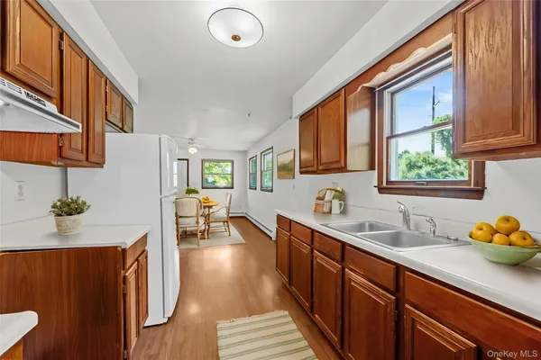 a kitchen with stainless steel appliances granite countertop a sink dishwasher stove and wooden cabinets