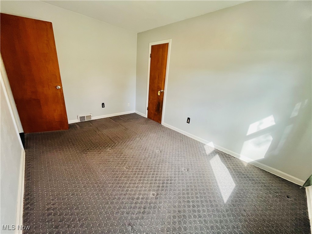 3210 Austinburg Road Ashtabula, OH 44004 - Photo 36 of 48 Empty room featuring baseboards, visible vents, and dark colored carpet
