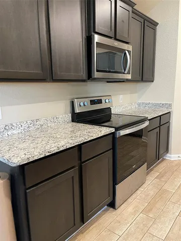 a kitchen with kitchen island sink refrigerator and microwave
