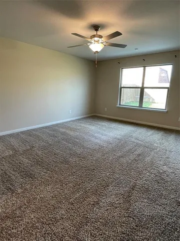 a view of an empty room with a chandelier fan
