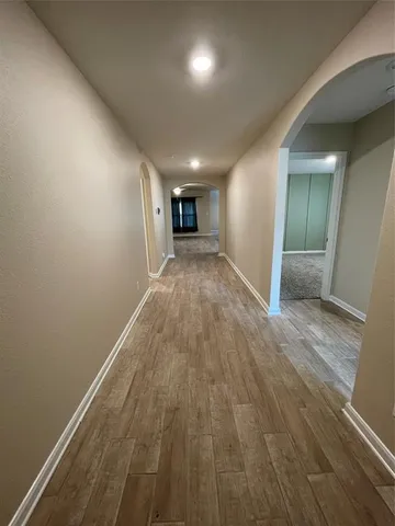 a view of a big room with wooden floor and windows