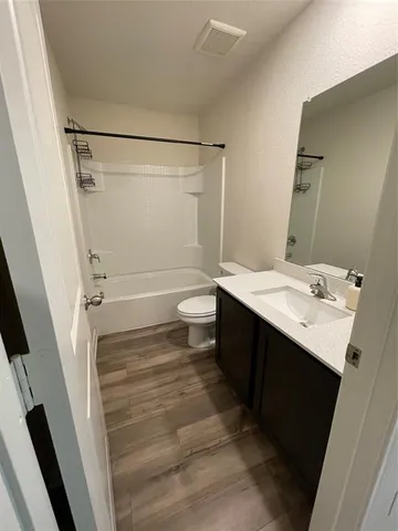 a bathroom with a sink a toilet a mirror and shower
