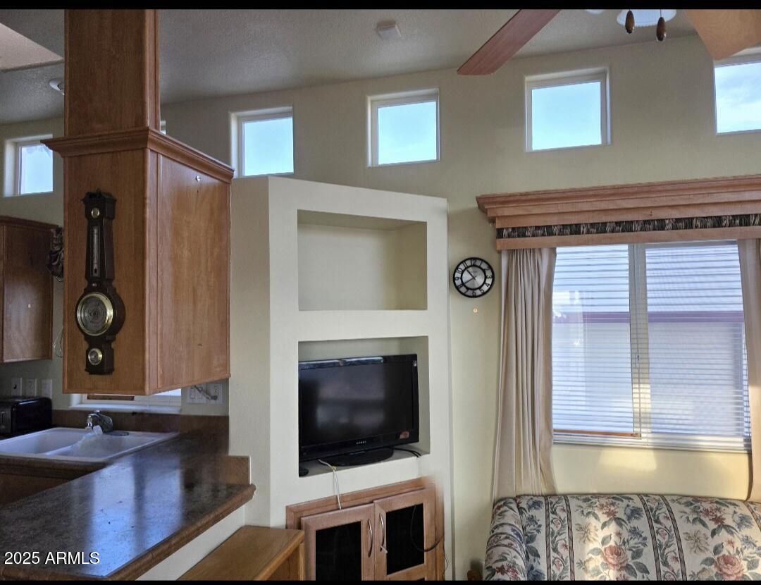 1347 West Inuit Avenue, Unit 347 Apache Junction, AZ 85119 - Photo 4 of 6 a living room with a fireplace and a flat screen tv