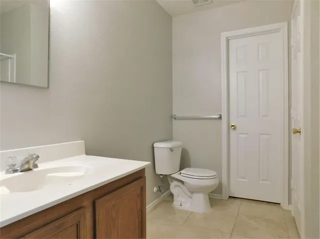 a bathroom with a granite countertop toilet and a sink