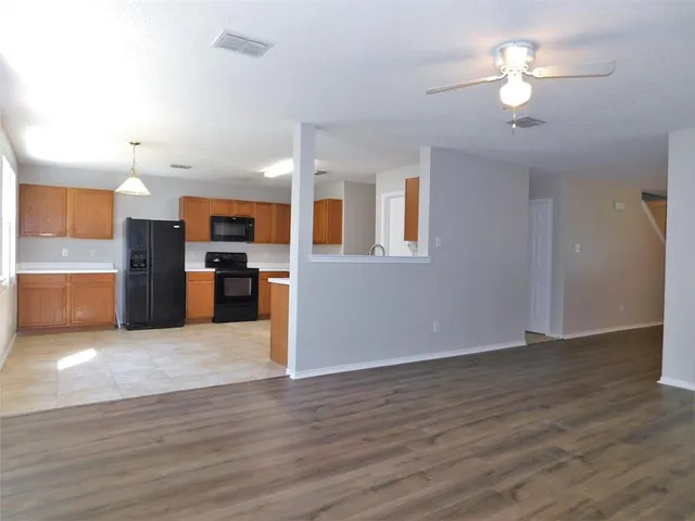 a view of kitchen with refrigerator stove and wooden floor