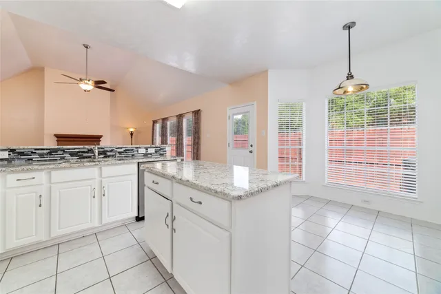 a kitchen with granite countertop white cabinets and white appliances