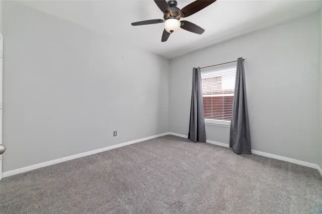 an empty room with closet and windows