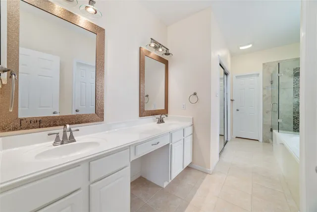 a bathroom with a double vanity sink mirror double and shower