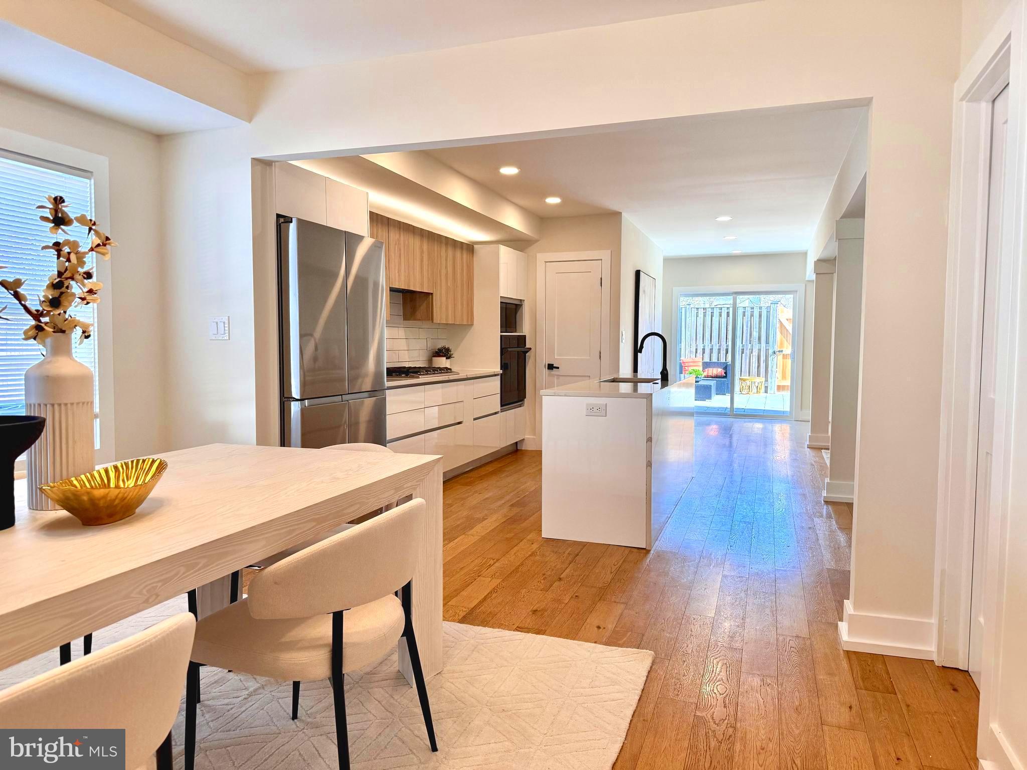 310 South Alfred Street Alexandria, VA 22314 - Photo 11 of 63 a dining hall with stainless steel appliances wooden floor dining table and chairs