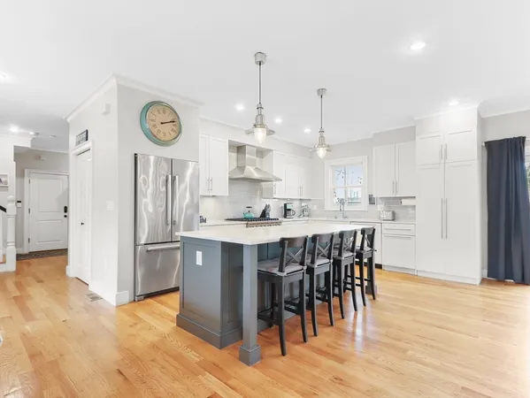 a kitchen with stainless steel appliances kitchen island granite countertop a sink a stove and a refrigerator