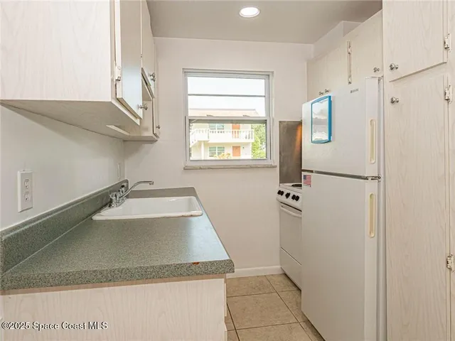 a view of a kitchen with a sink and dishwasher a refrigerator with wooden floor