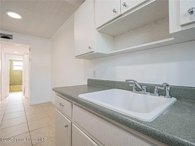 a bathroom with a granite countertop sink and washing machine