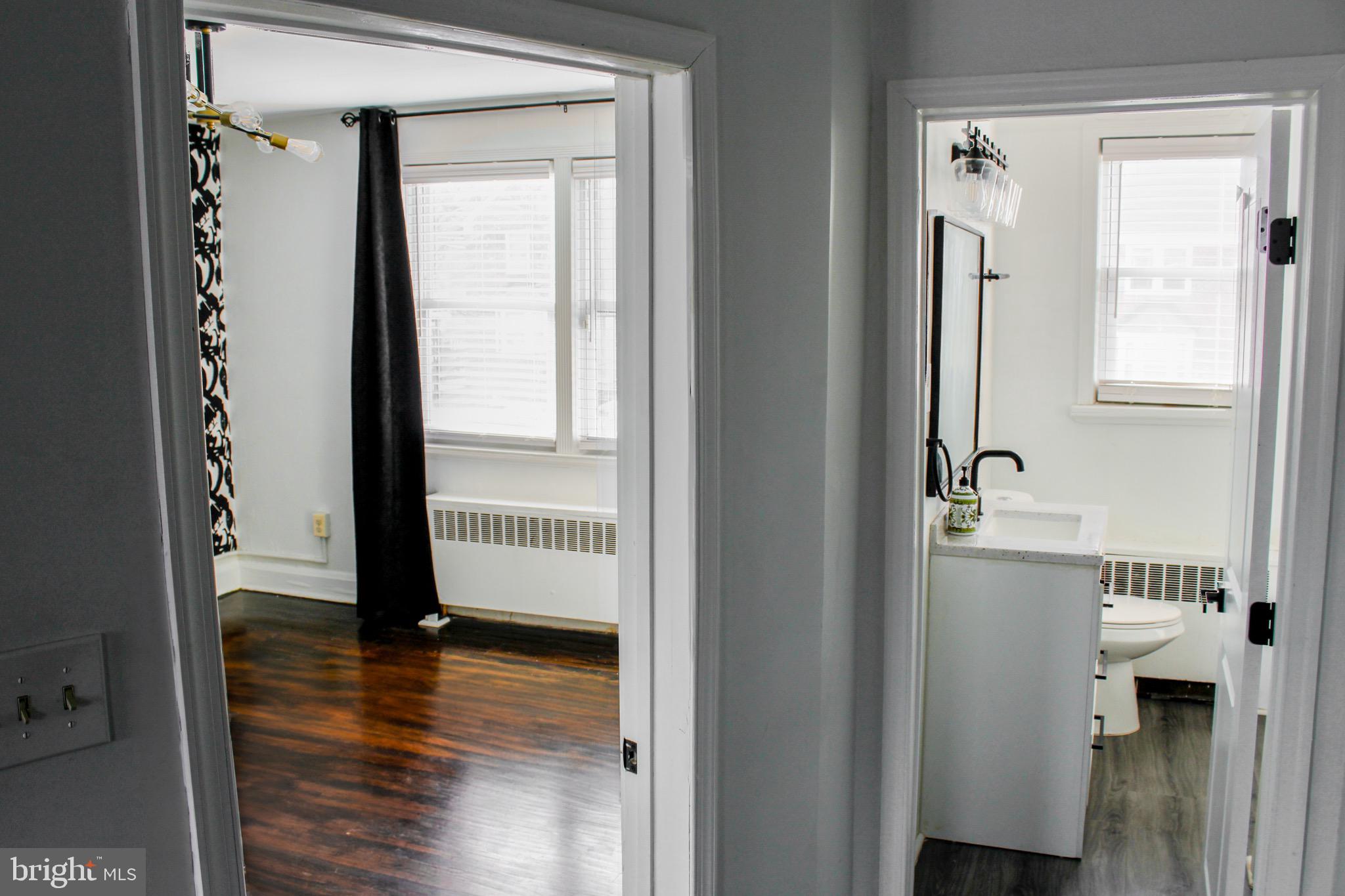 6161 Parkway Drive, Unit 2 Baltimore, MD 21212 - Photo 19 of 24 a view of a hallway with wooden floor and a bathroom