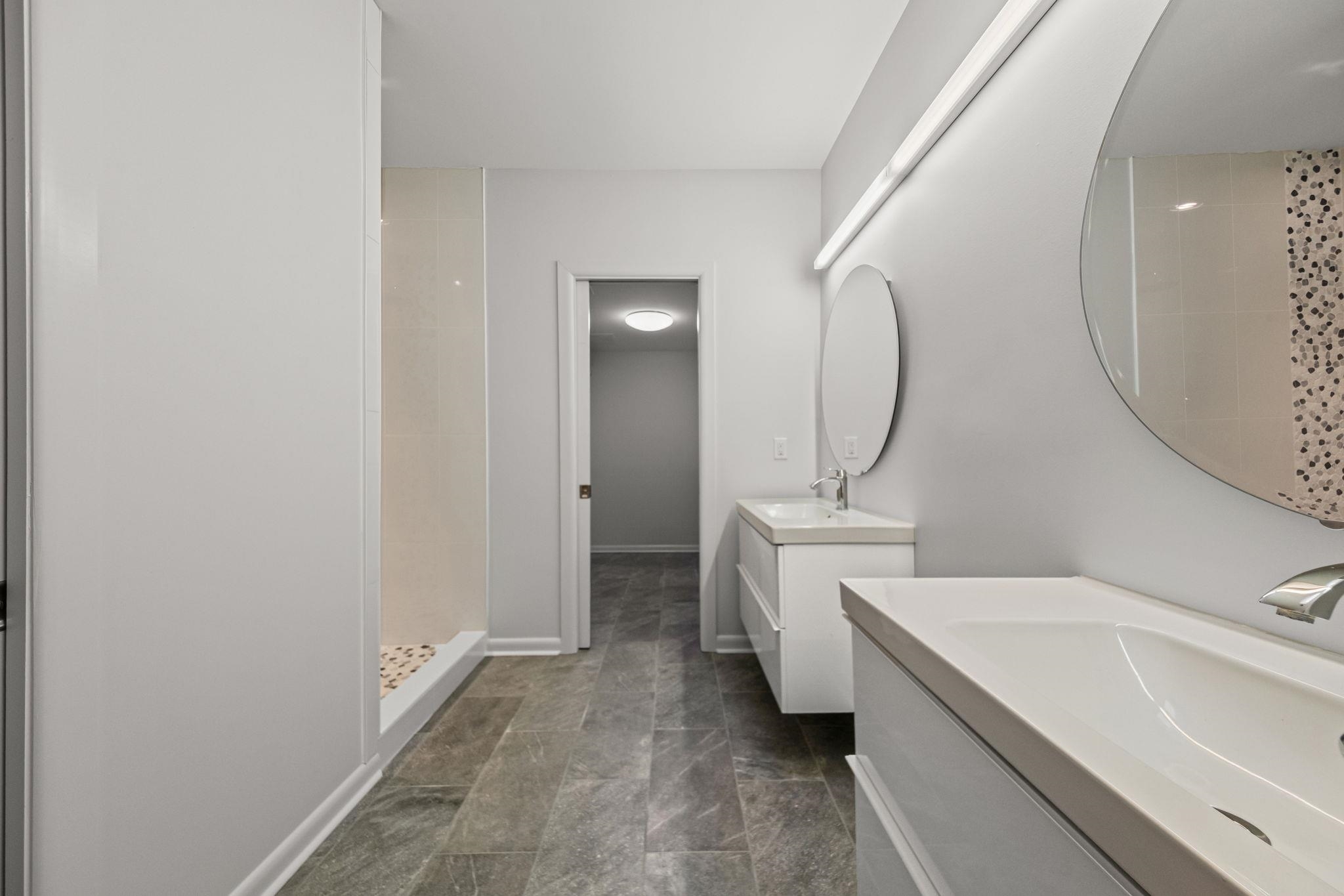 448 Tennessee Street Memphis, TN 38103 - Photo 22 of 39 Modern bathroom featuring a dual vanity with undermount sinks and wall-mounted mirrors