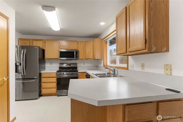 a kitchen with stainless steel appliances granite countertop a stove microwave refrigerator and cabinets