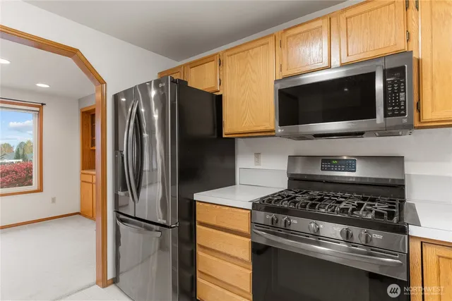 a kitchen with stainless steel appliances a stove sink and microwave