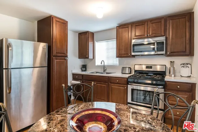 a kitchen with stainless steel appliances granite countertop a refrigerator stove and microwave