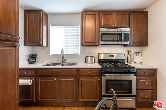 a kitchen with cabinets appliances and a counter space