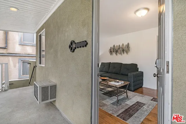 a view of a hallway to a livingroom with furniture and windows
