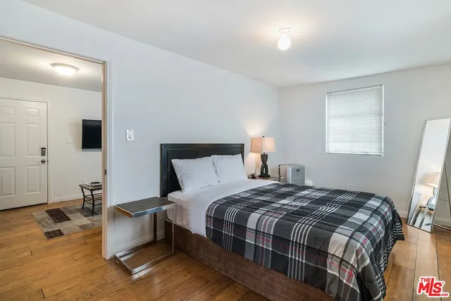 a bedroom with a bed and a large mirror