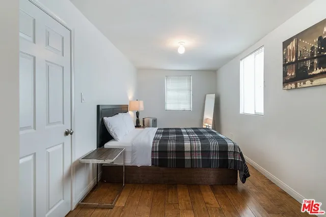 a bedroom with a bed and wooden floor