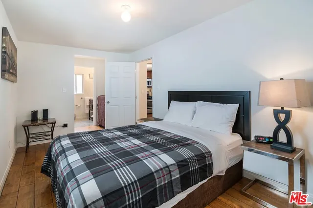 a bedroom with a bed and wooden floor