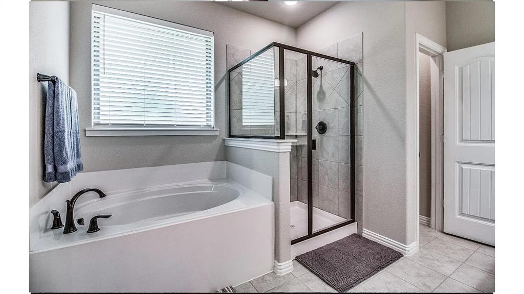 709 Copley Street Sherman, TX 75090 - Photo 13 of 27 a bathroom with a bathtub and a shower