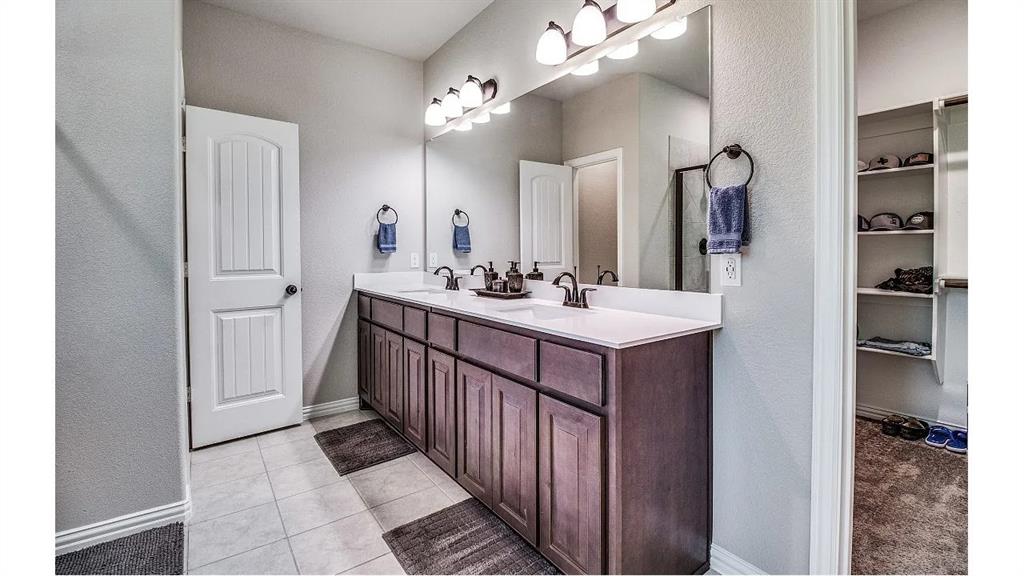 709 Copley Street Sherman, TX 75090 - Photo 14 of 27 a bathroom with a double vanity sink and a mirror