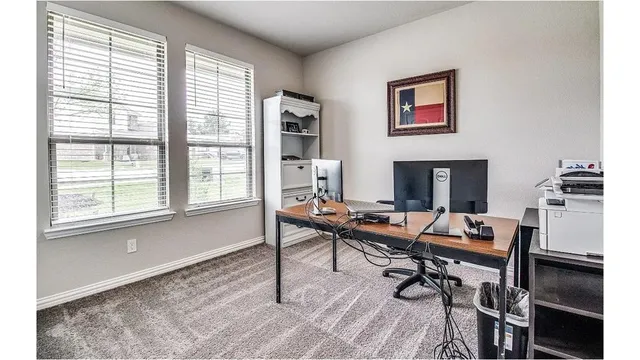 a view of a workspace with furniture and a window