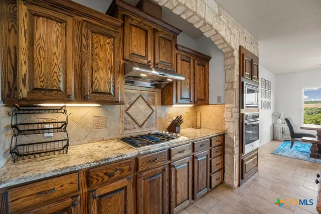 a bathroom with a granite countertop sink a toilet and a shower curtain