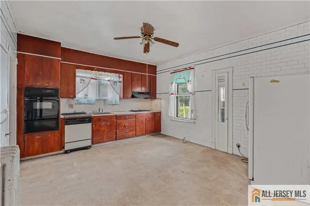 a large kitchen with stainless steel appliances double vanity and a refrigerator