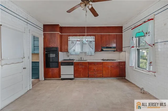 a large kitchen with stainless steel appliances granite countertop a stove a sink and a refrigerator