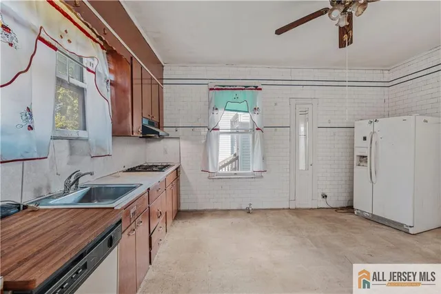 a kitchen with granite countertop a sink stove and cabinets