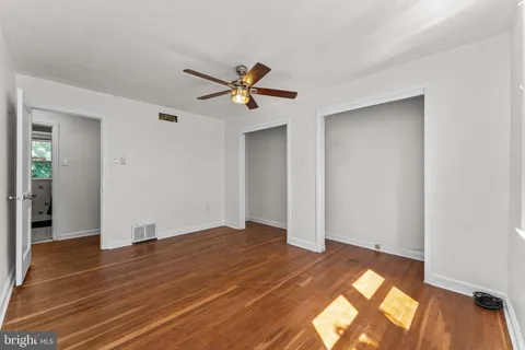 a view of a room with wooden floor and ceiling fan