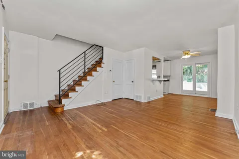 a view of empty room with wooden floor and stairs