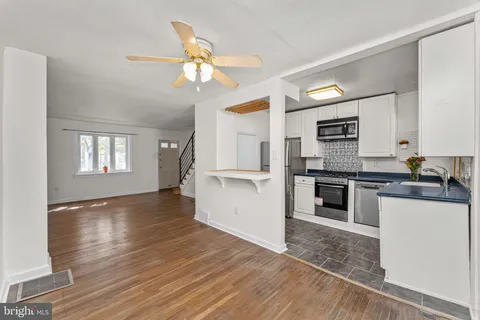 a kitchen with granite countertop a refrigerator and a stove top oven