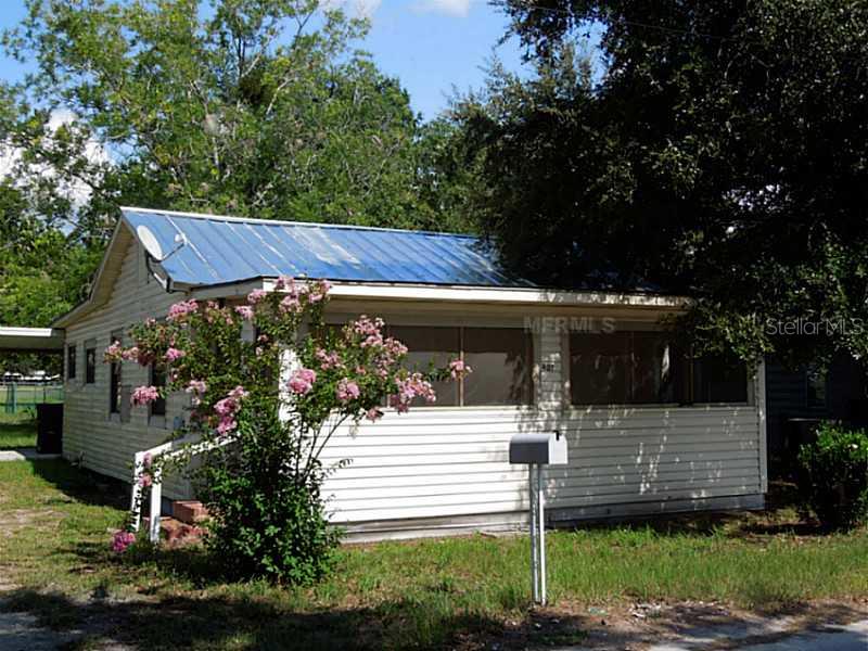 407 Cardinal Street Eustis, FL 32726 - Photo 1 of 1 a view of a house with a small yard plants and large tree