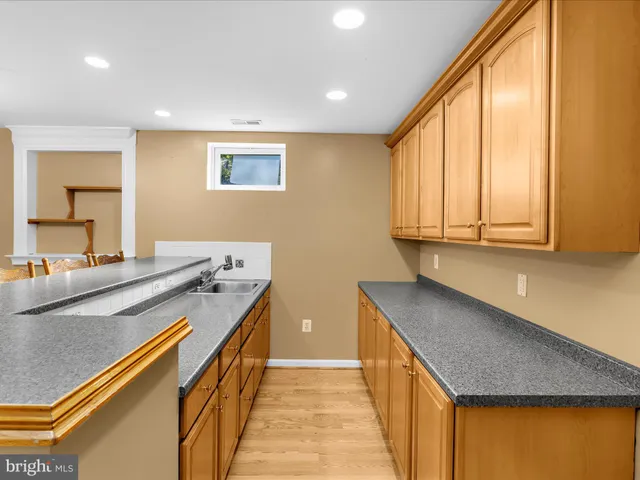 a bathroom with a granite countertop sink a toilet and a mirror